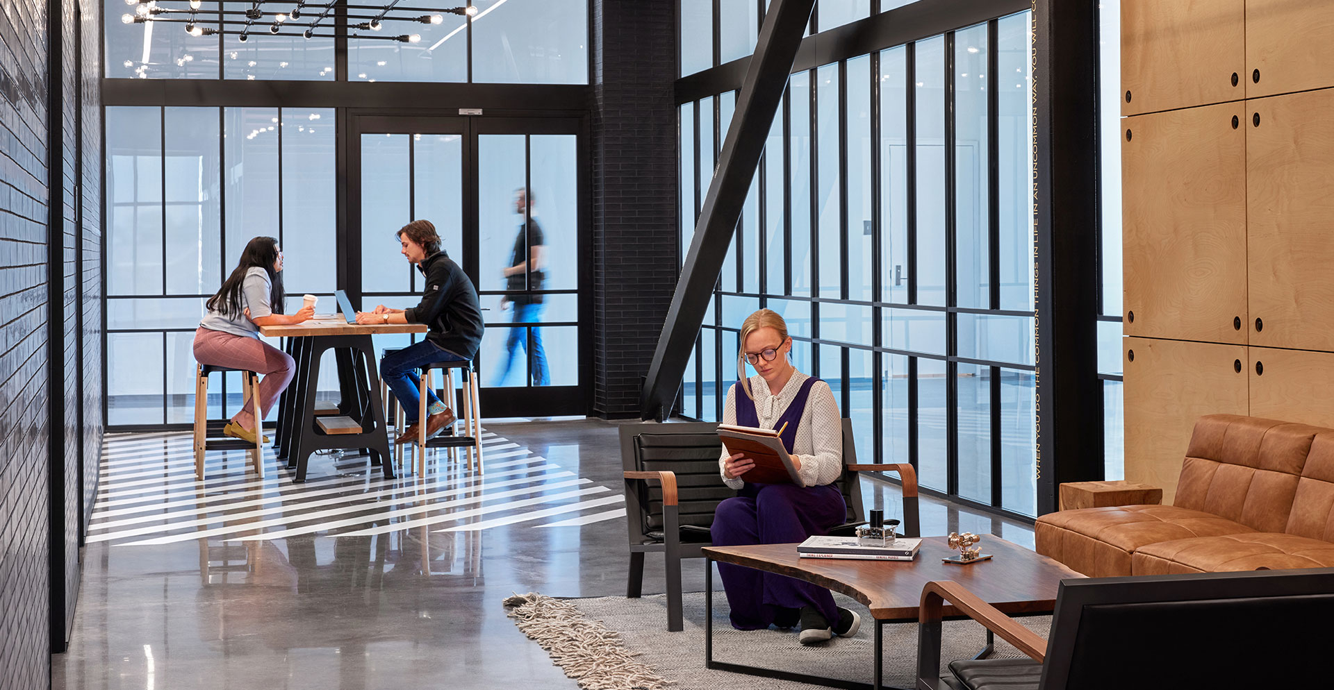 A group of people sitting at a table in a room with windows.