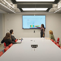 4 people viewing the office-to-residential algorithm on a large screen in a conference room