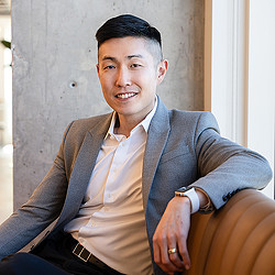 A person in a suit smiling.