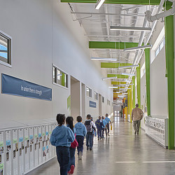 A group of people walking in a hallway.