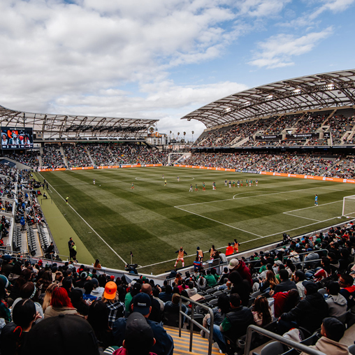 A sports stadium with a field and a crowd of people.