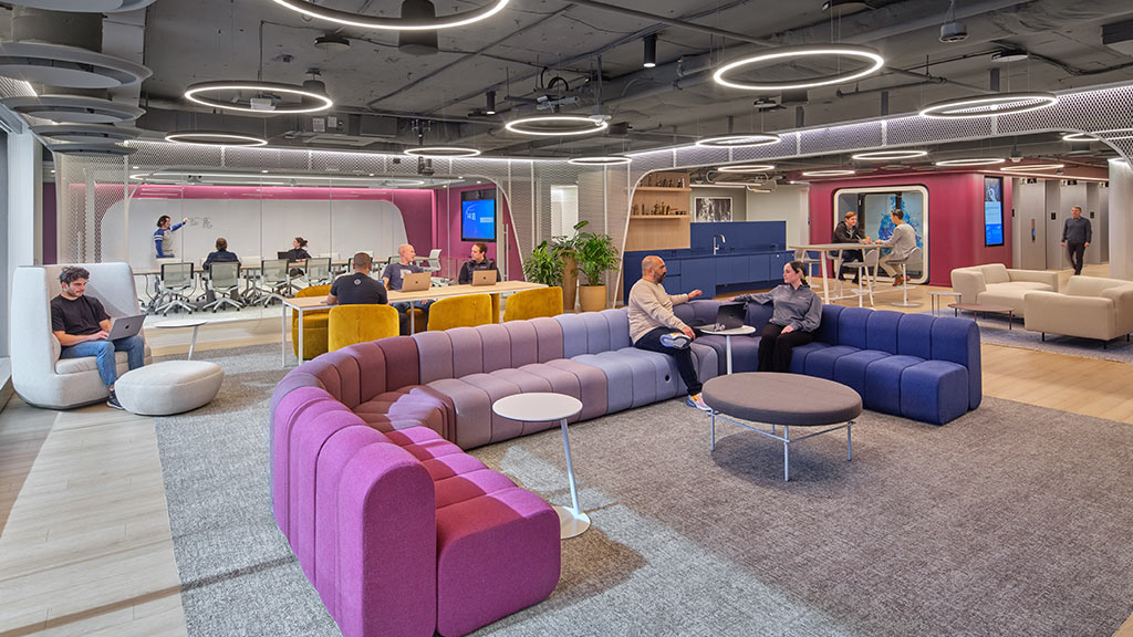 A group of people sitting in a room with purple couches at Virtru headquarters