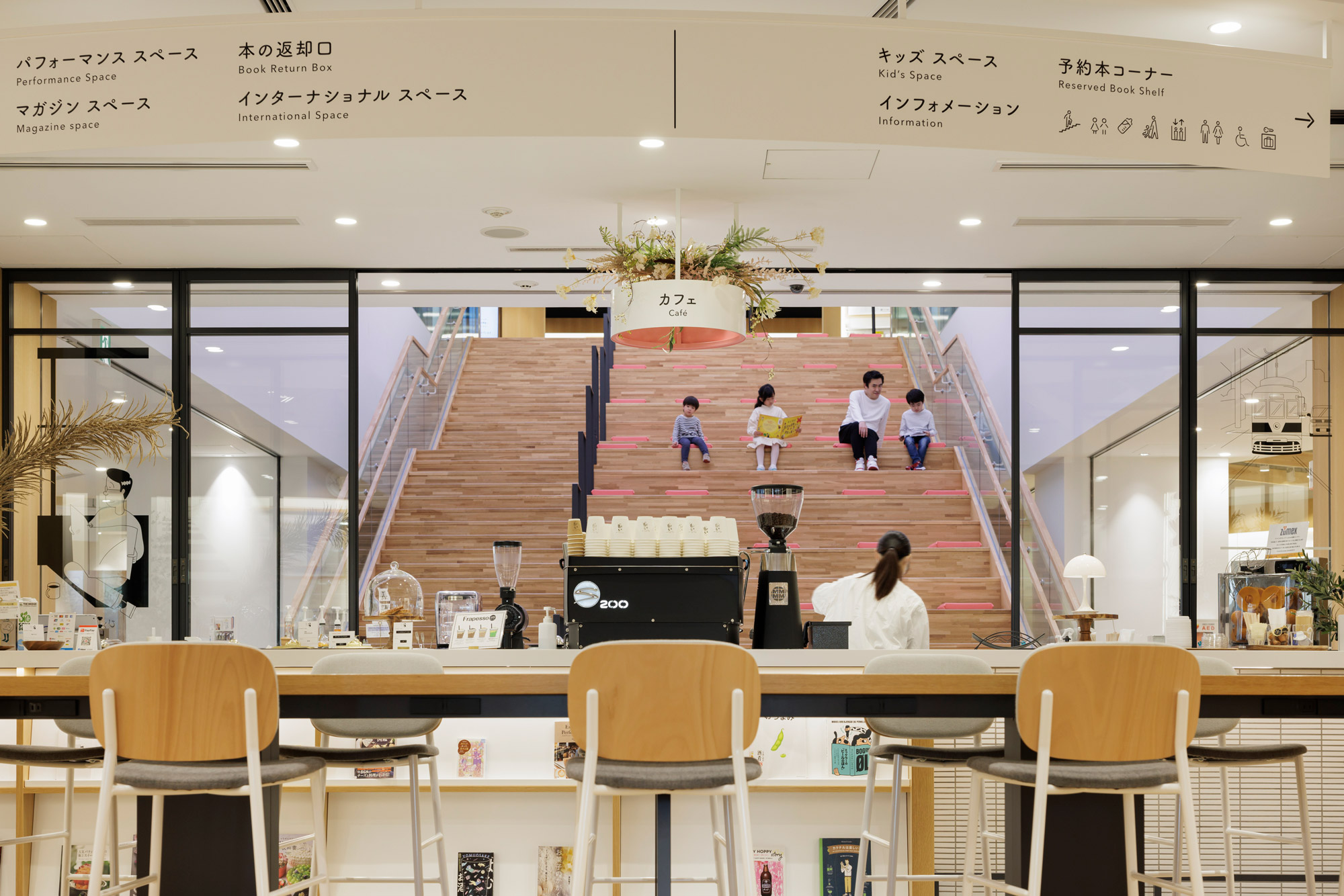 A room with tables and chairs and a staircase with people walking around.