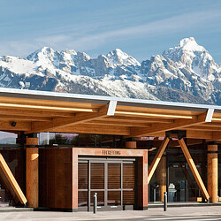 A building with snow covered mountains in the background.