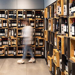 A person in a store with shelves of wine.