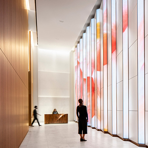 A person and a child walking in a hallway.
