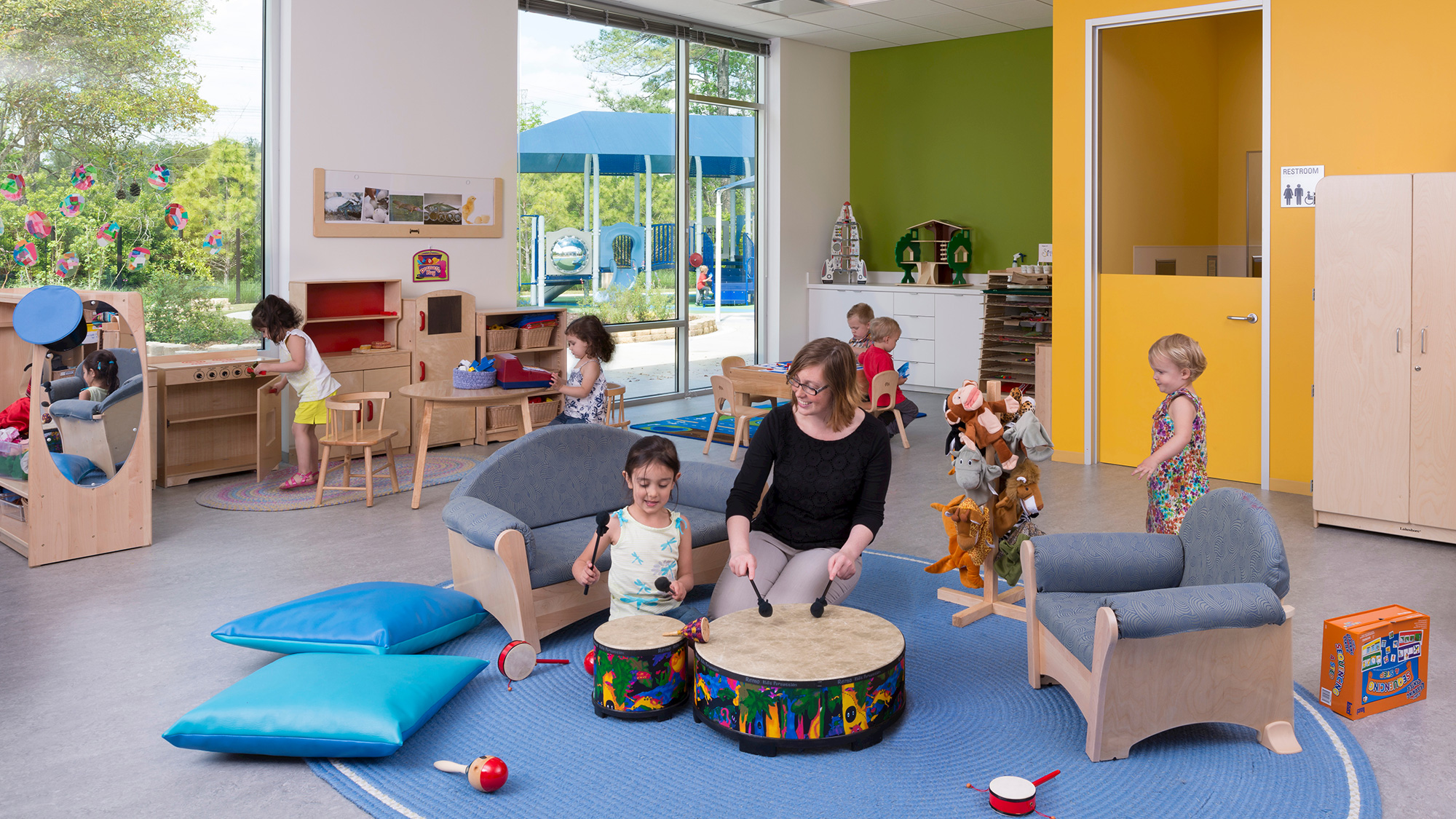 A group of people playing in a room with a dog and a person.