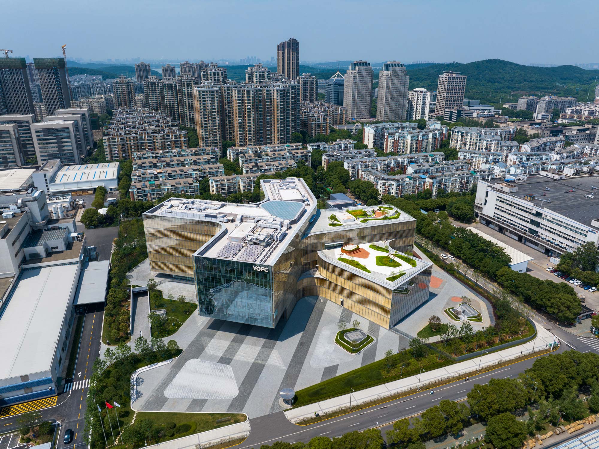 A large building with a courtyard in front of a city.