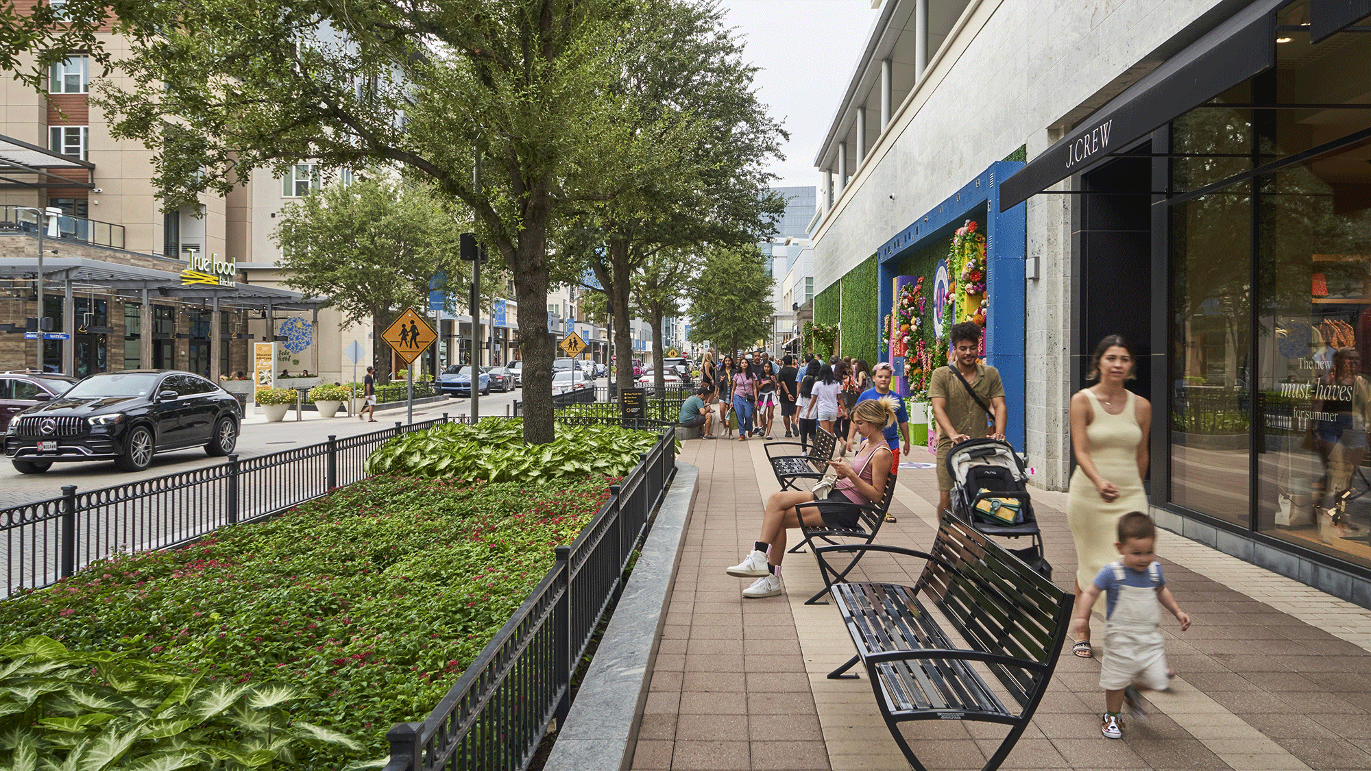 A group of people walking on a sidewalk.