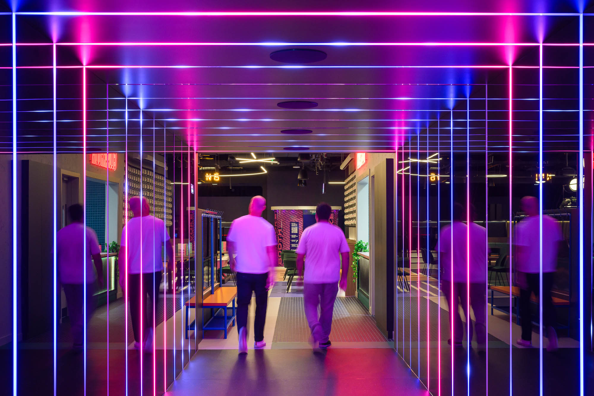 Two people walking through TOCA Social Birmingham light-up tunnel