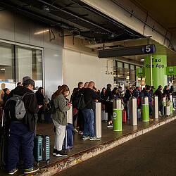 Travelers at LAX wait for the shuttle to a ride-hailing pickup area. (Sean Scheidt for The Washington Post)