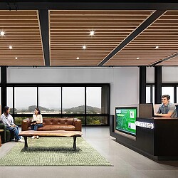 A group of people sitting in a room with a large screen.