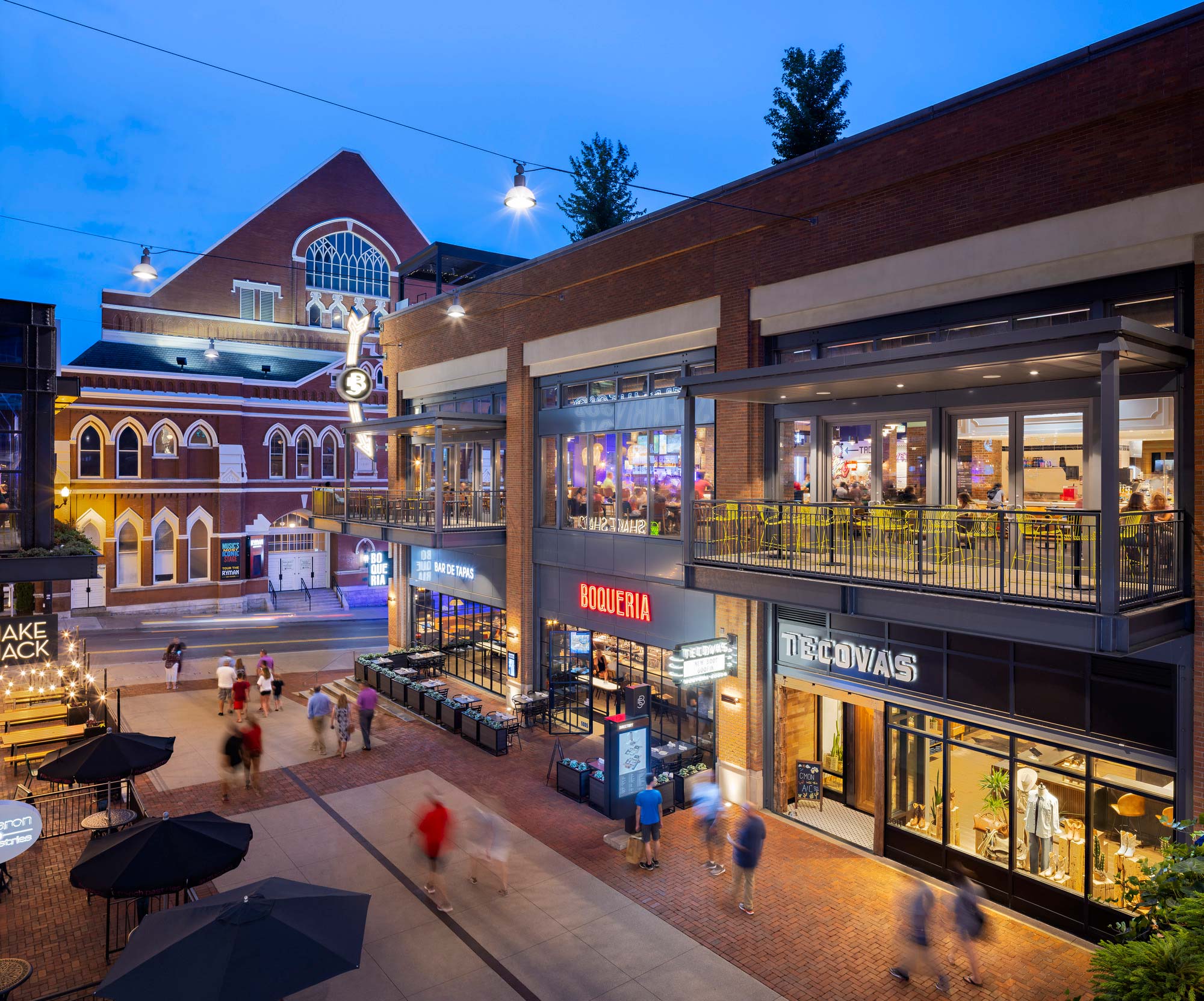 A group of people walking around a shopping mall.