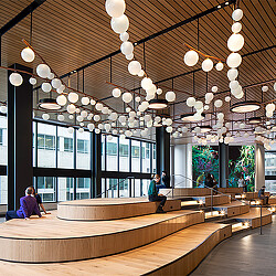 A large room with a large chandelier and a couple of people sitting at a table.