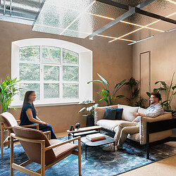 A man and woman sitting on a couch and lounge chair at Hilson Moran’s Living Lab