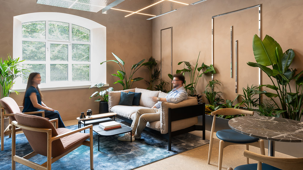 A man and woman sitting on a couch and lounge chair at Hilson Moran’s Living Lab