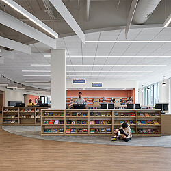 A few people sitting in a library.