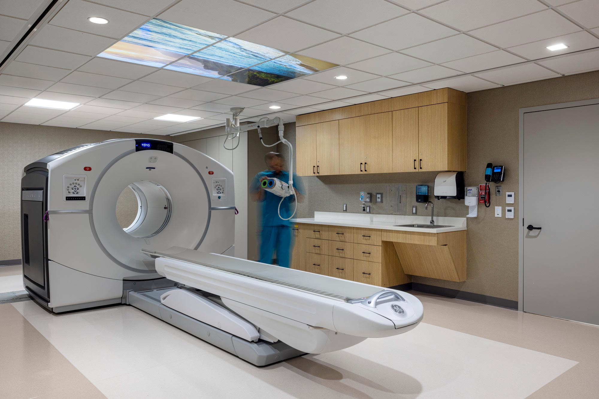 A person standing in a room with a large white machine.