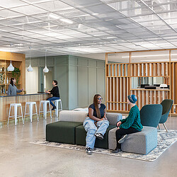 A group of people sitting on a couch in a room with a table and chairs.