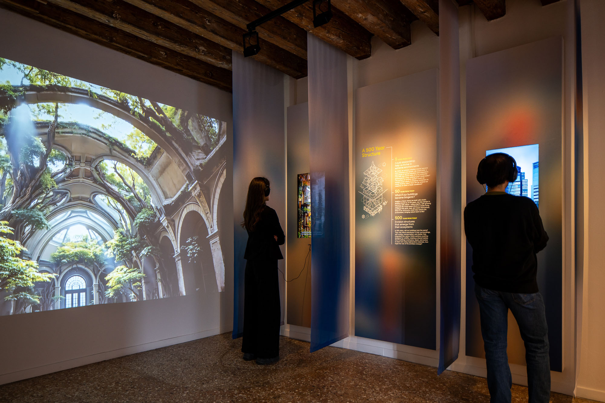 A man and woman looking at a large painting on a wall.