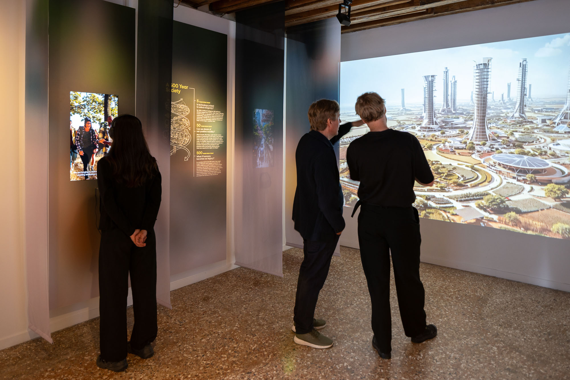 A group of people looking at a large painting on a wall.
