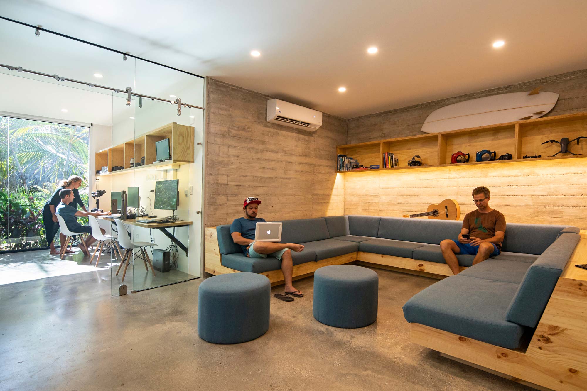 A group of people sitting on couches in a room with a large window.