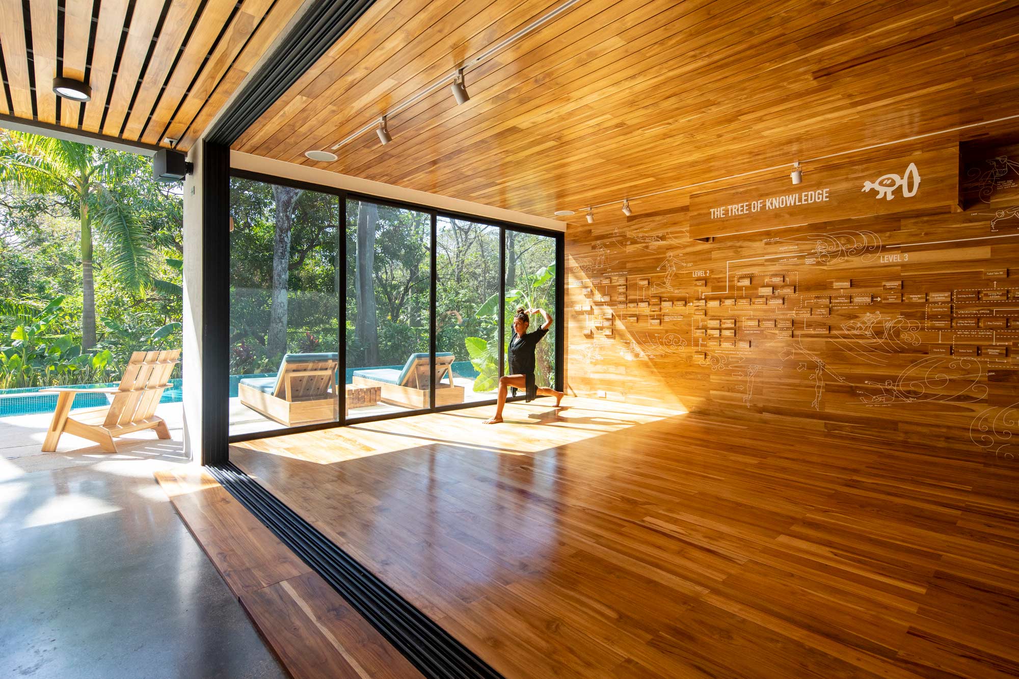 A person standing in a room with large windows.