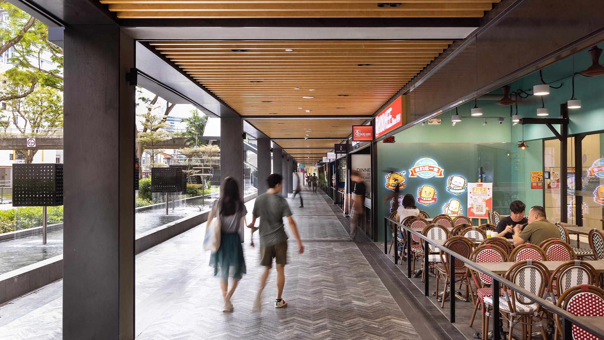 A couple walking down Shaw Plaza Balestier breezeway