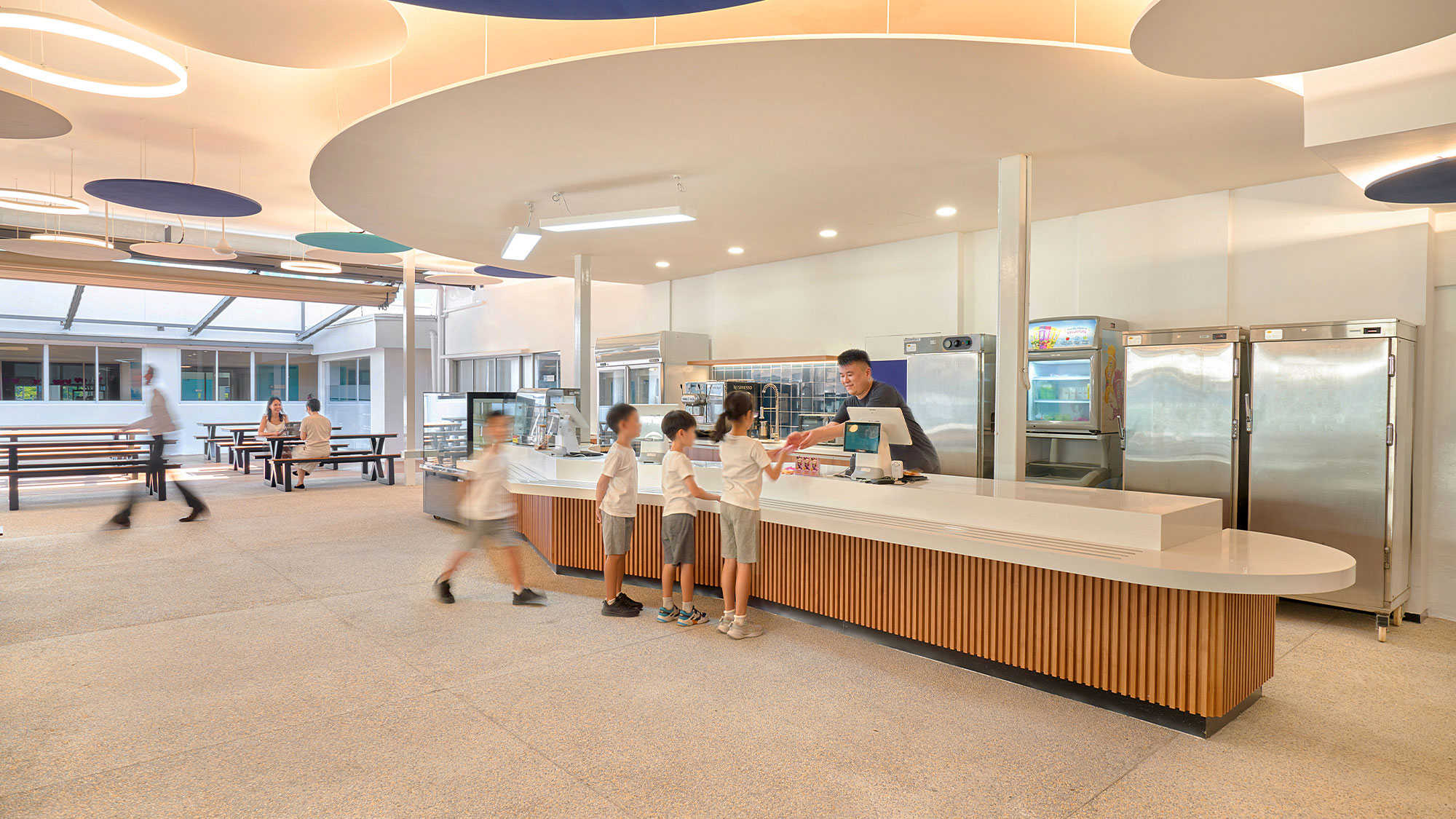A group of people standing in front of a counter in a large building.