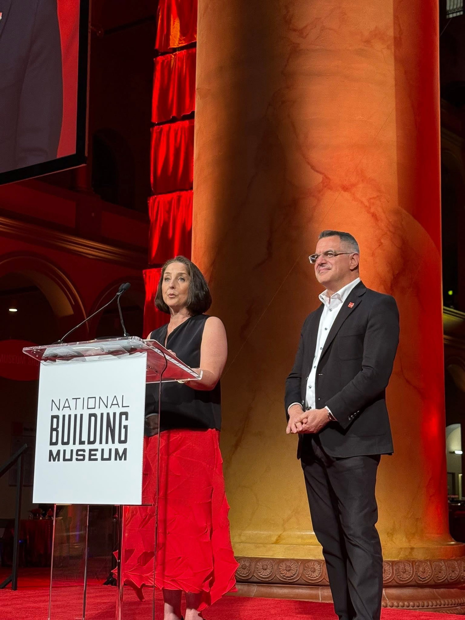 A man and woman standing on a stage.