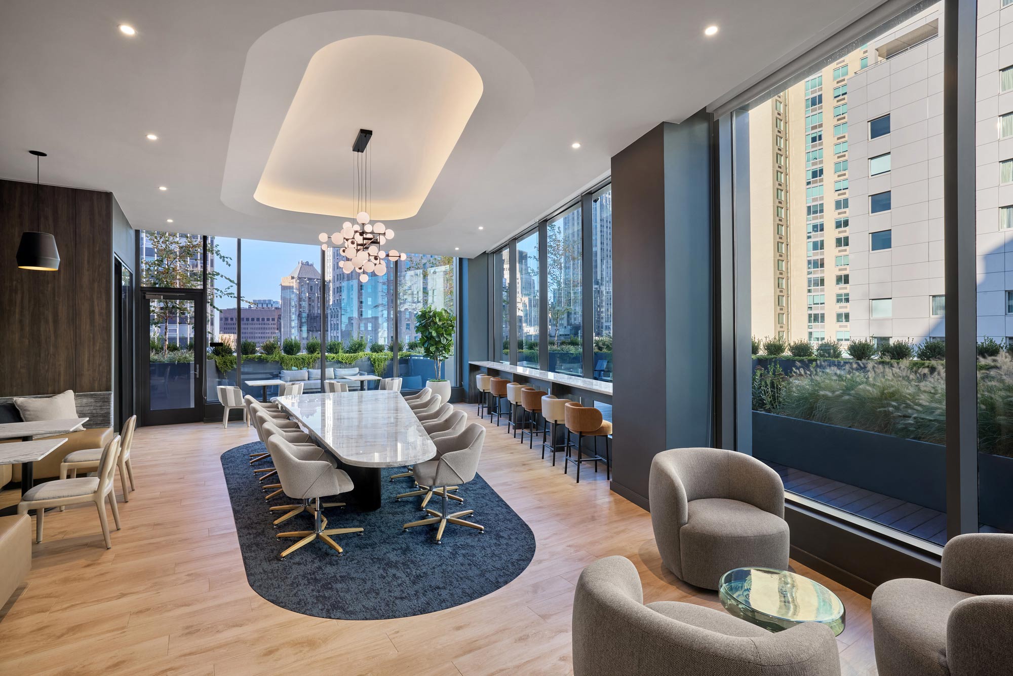 A room with a table chairs and a large window.