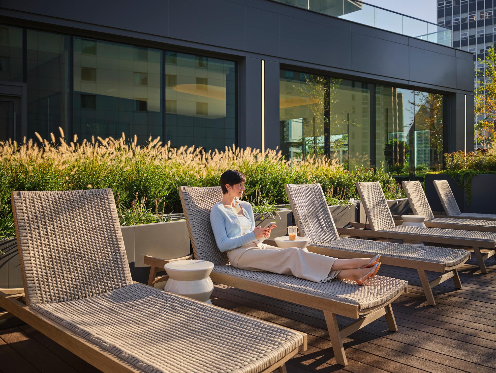 A person sitting on a lounge chair outside.