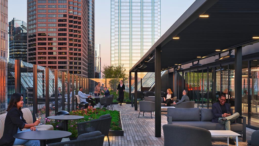 A group of people sitting in a room with tall buildings.