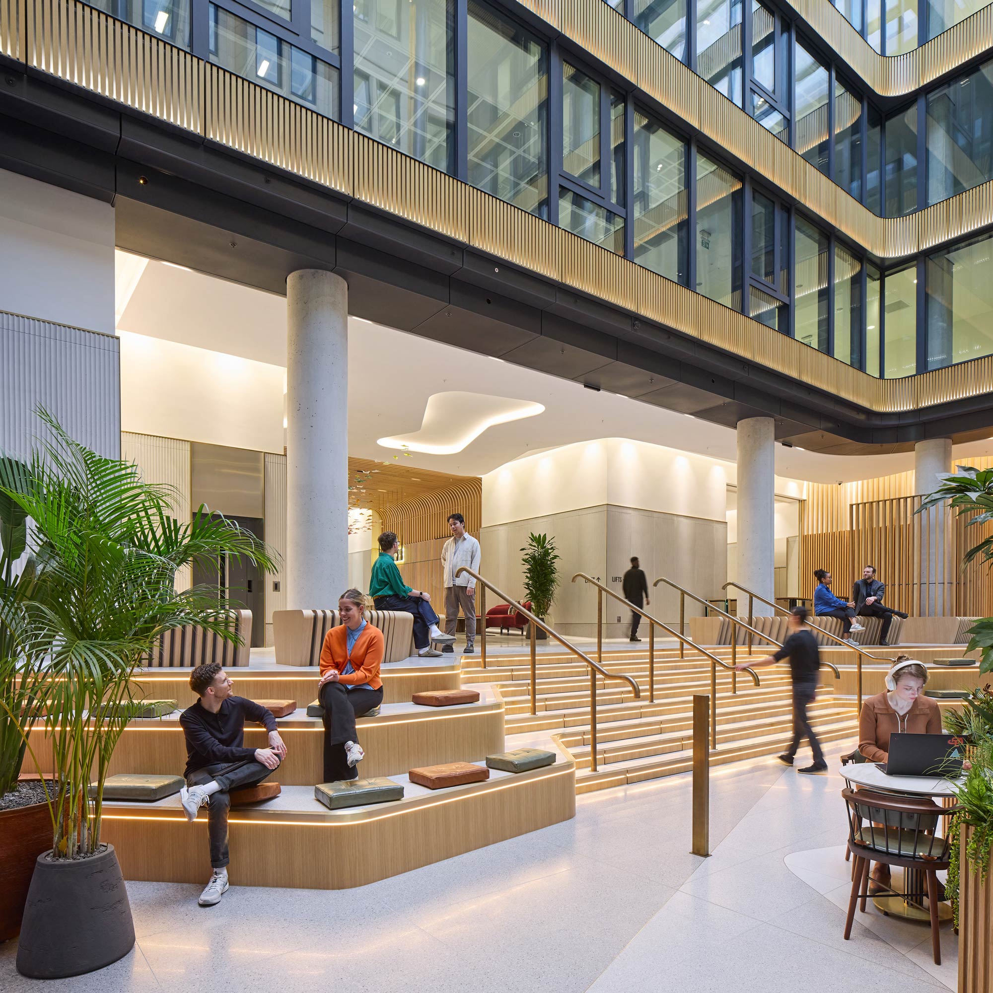 People sitting on stairs in a building.