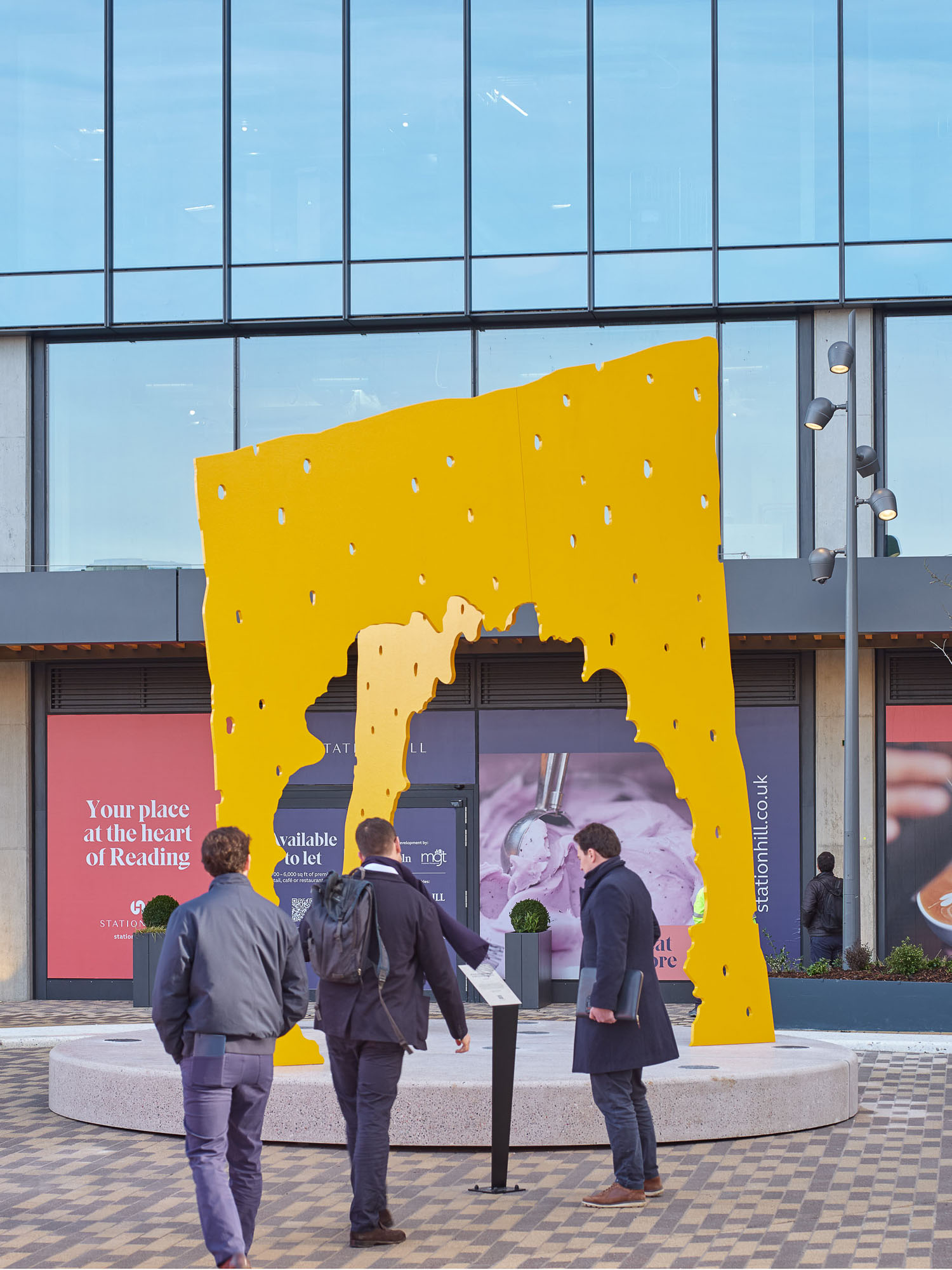 A group of people standing in front of yellow sculpture