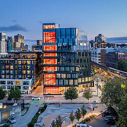 222 Fifth building with illuminated red stairs and Seattle cityscape
