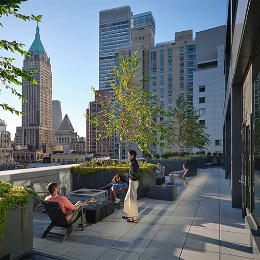 A group of people sitting on the rooftop of Gensler’s Pearl House, a residential building converted from an office.