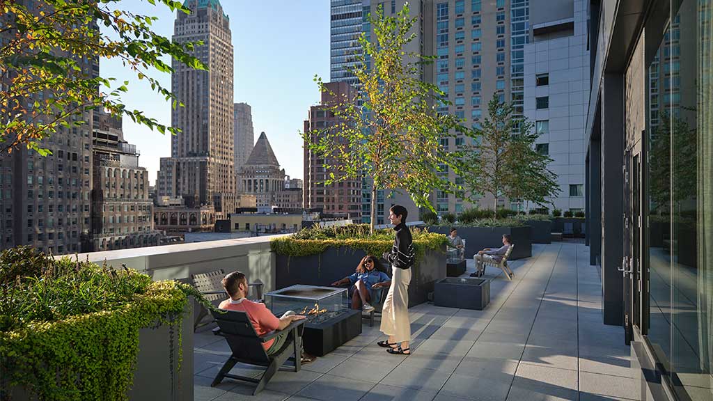 A group of people sitting on the rooftop of Gensler’s Pearl House, a residential building converted from an office.