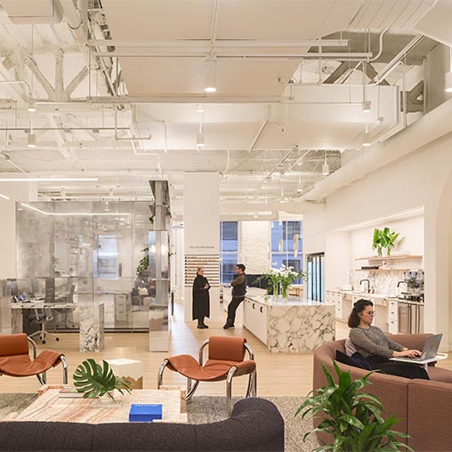 A couple of people are working and socializing in the hallway of Gensler's San Francisco Office.