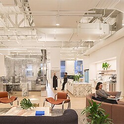 A couple of people are working and socializing in the hallway of Gensler's San Francisco Office.