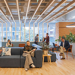 A group of people sitting in a room with a large window.