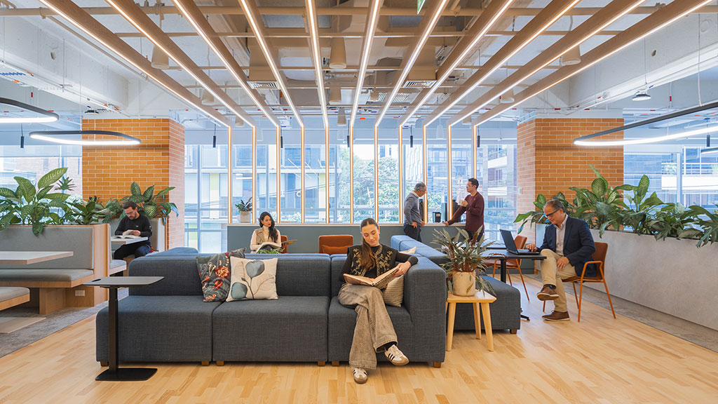 A group of people sitting in a room with a large glass ceiling.