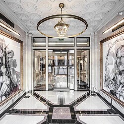 A room with a chandelier and glass walls.