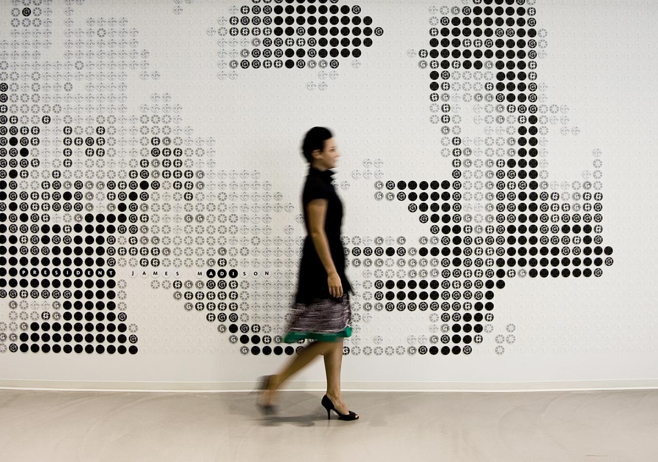 A man walking in front of a wall of text.