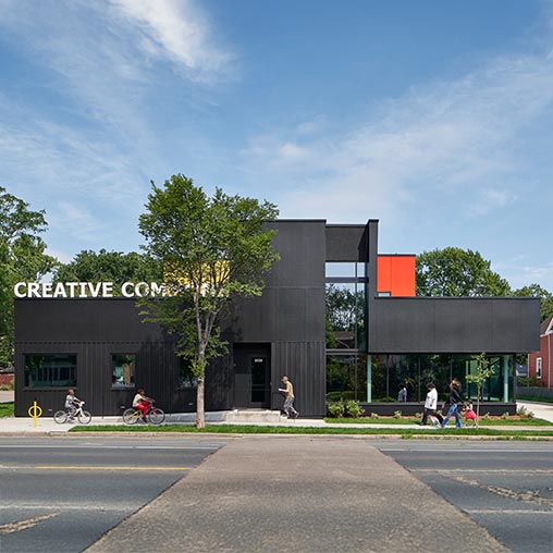A building with a tree in front.
