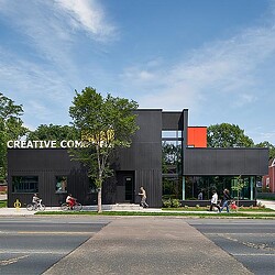 A building with a tree in front.