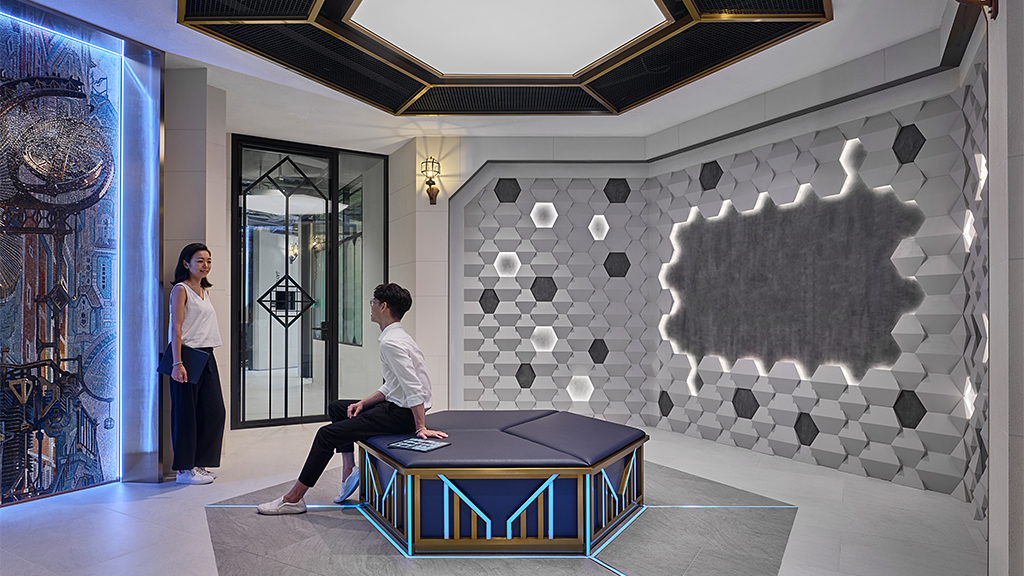 A man and woman sitting on a table in a room with a wall of art.