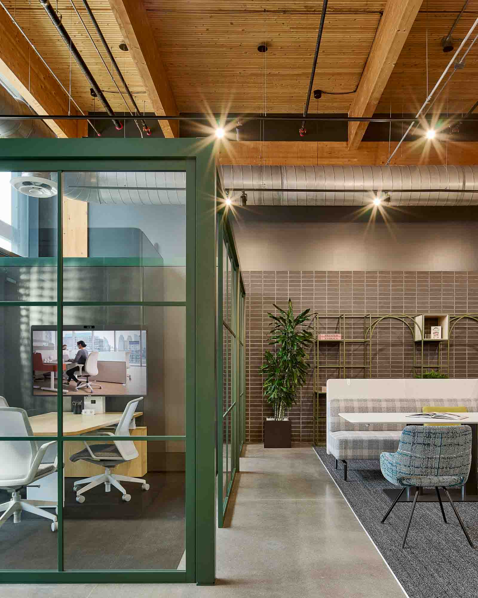 A room with a glass door and a table with chairs and a plant.