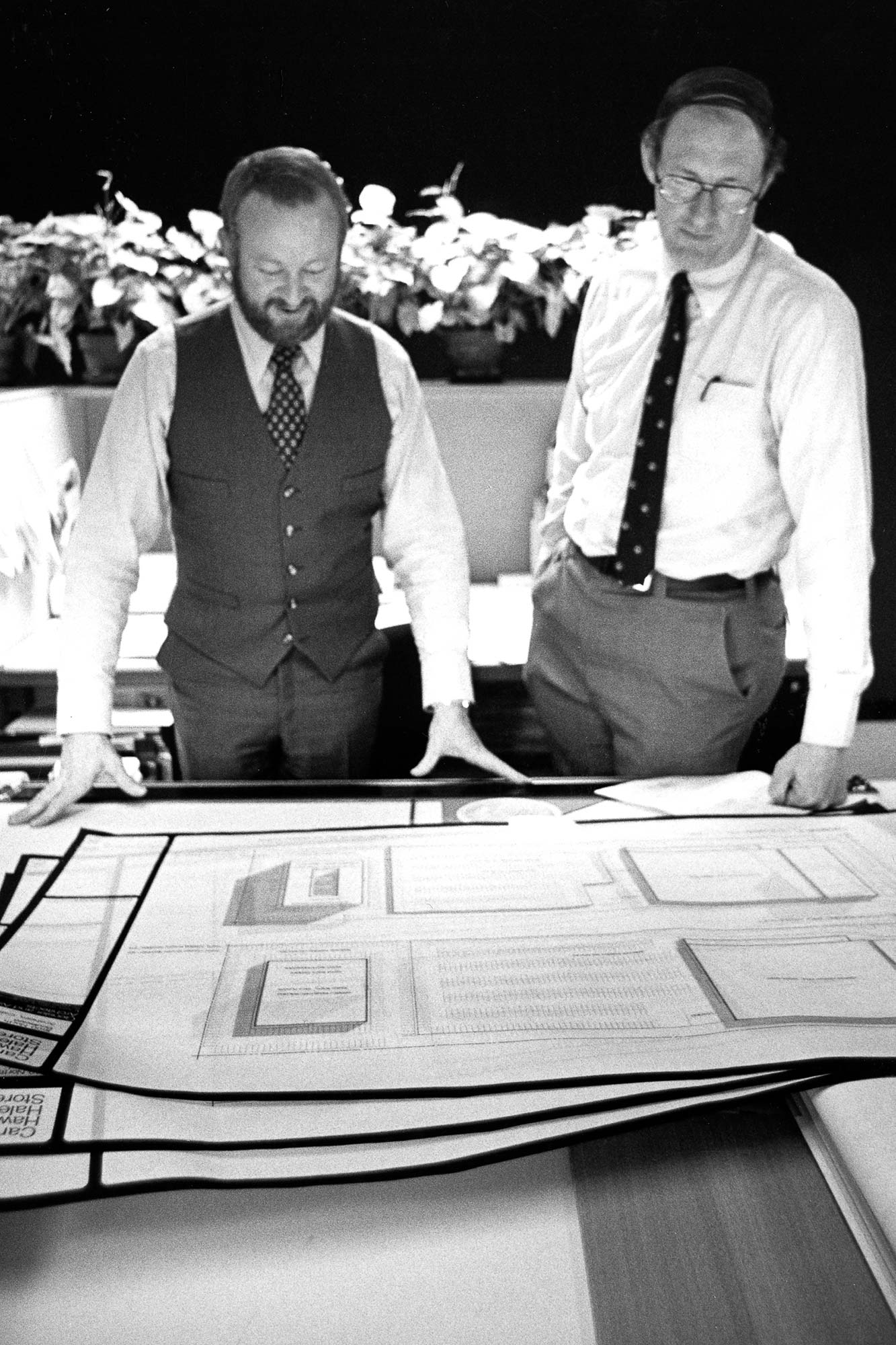 A couple of men standing next to a table with a game board.