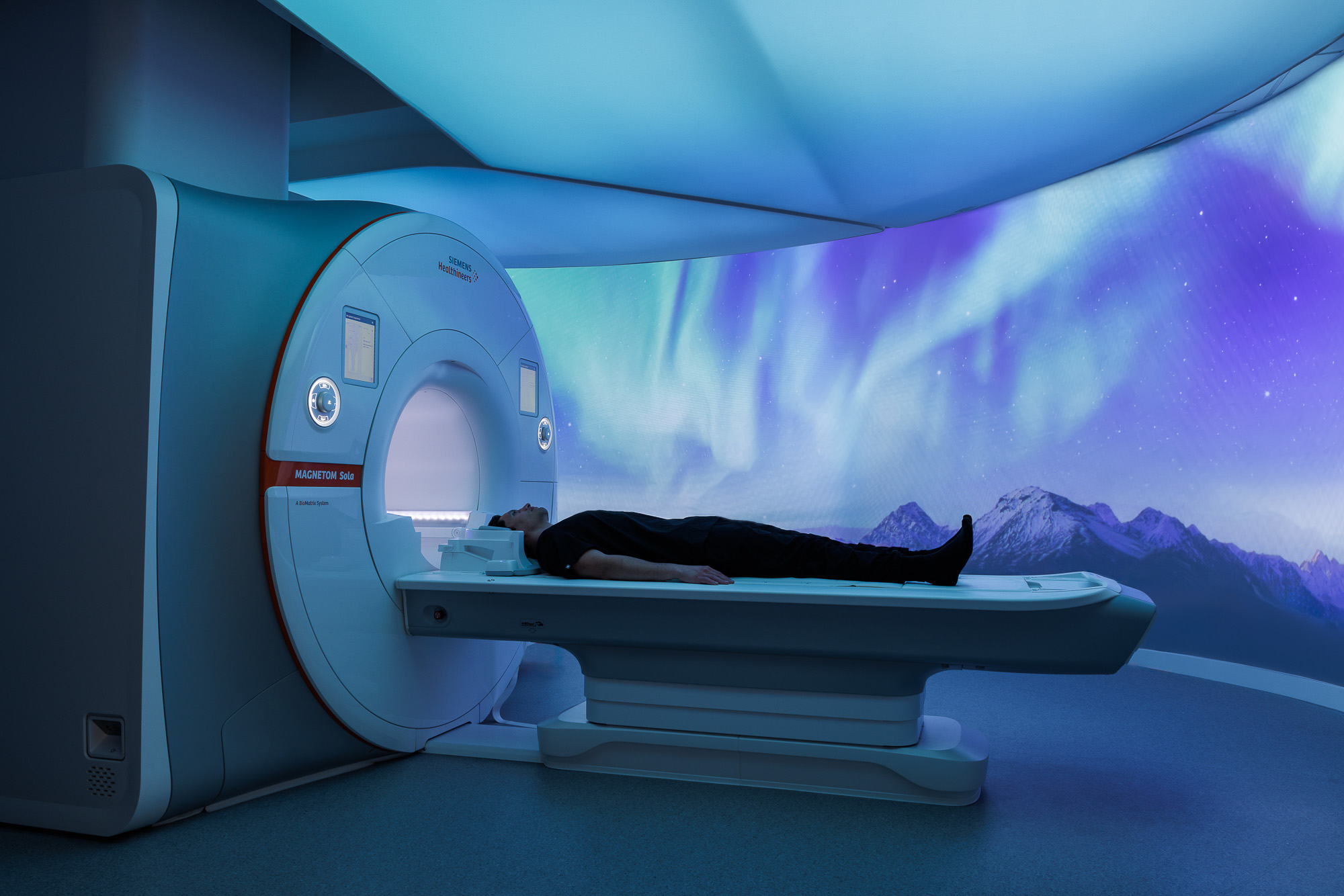 A person lying in a large machine.